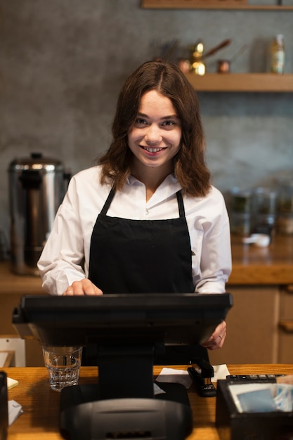 SmileyGeschäftsfrau, die am Kassierer arbeitet