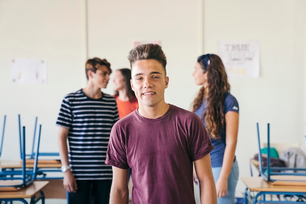 Smileyjunge posiert im Klassenzimmer