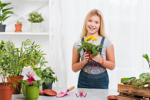 Smileymädchen, das Blumentopf hält