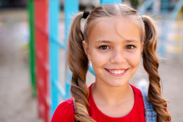 Smileymädchen mit dem blonden Haar, das Kamera betrachtet