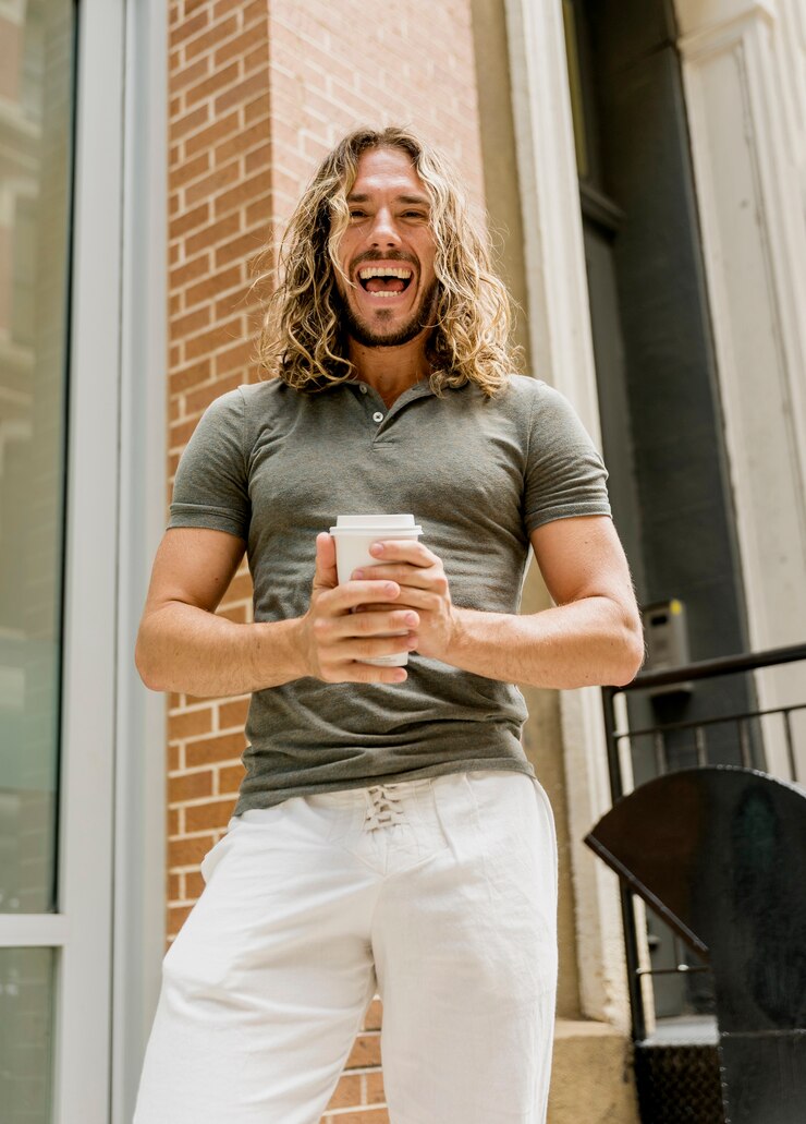 Kostenlose Foto smileymann, der den kaffee im freien genießt