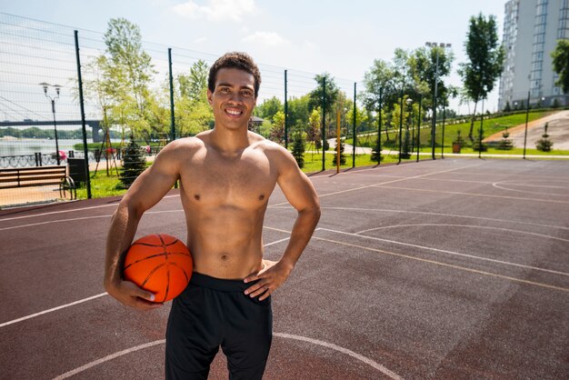 Smileymann, der einen Ball in einem städtischen Park hält