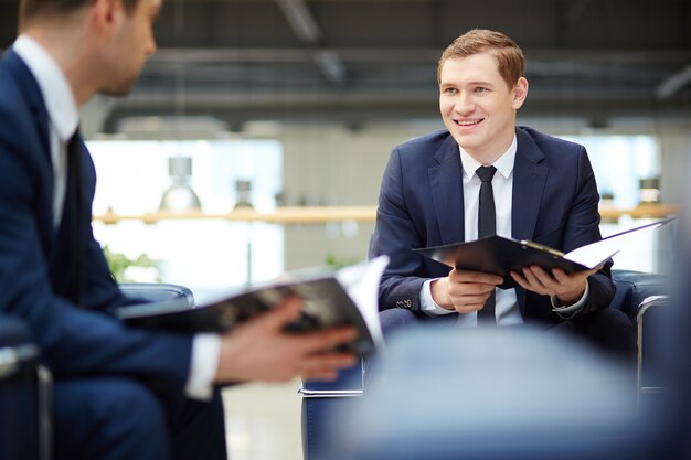 Smiling Geschäftsmann mit dem Programm des Treffens