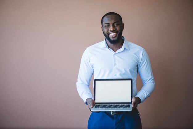 Smiling Geschäftsmann präsentiert Laptop