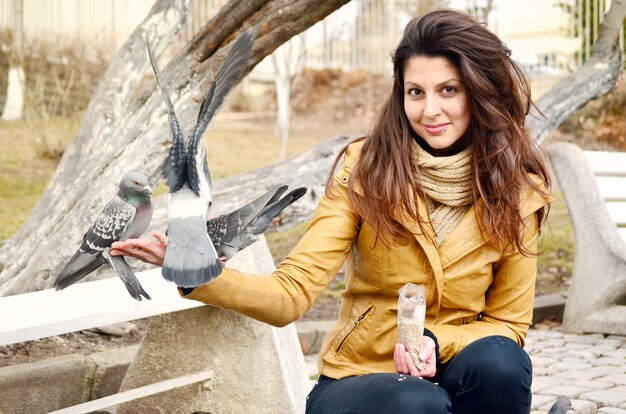 Smiling Mädchen mit Tauben in der Hand zu essen