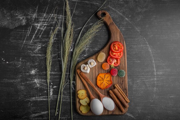 Snackbrett mit Ei, Tomaten und Gebäck in der Mitte