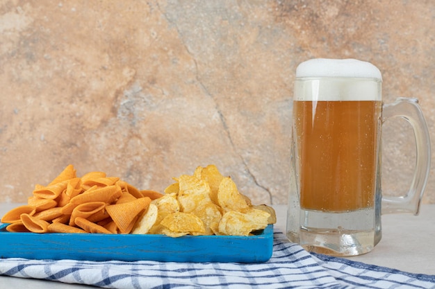 Kostenloses Foto snackplatte und glas bier auf tischdecke