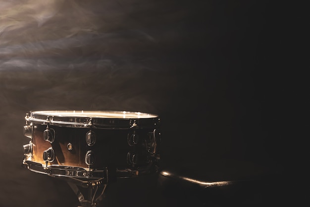 Snare Drum auf schwarzem Hintergrund, Schlaginstrument im Dunkeln mit Bühnenrauch, Kopierraum.