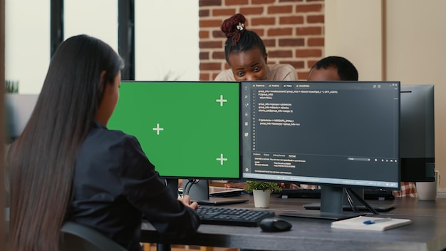 Kostenloses Foto softwareentwickler schreibt algorithmus vor computer mit green-screen-chroma-key-mockup in der ki-entwicklungsagentur. entwickler von cybersicherheits-apps, die software für maschinelles lernen programmieren.