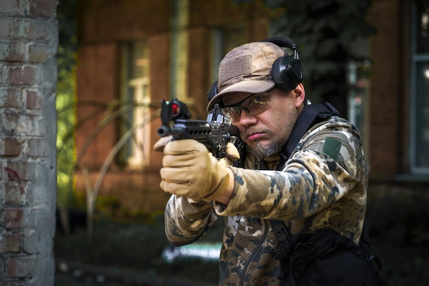 Soldat versteckt sich in Position mit Waffe in den Händen Ranger während der Militäroperation