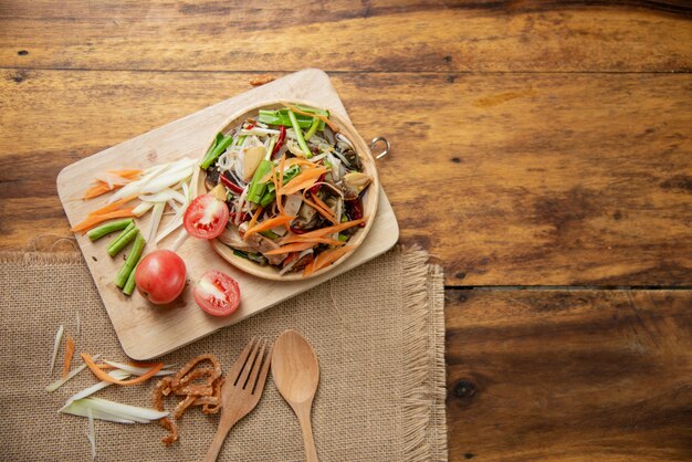 Som Tam Thai, thailändischer Papaya-Salat auf hölzernem Hintergrund