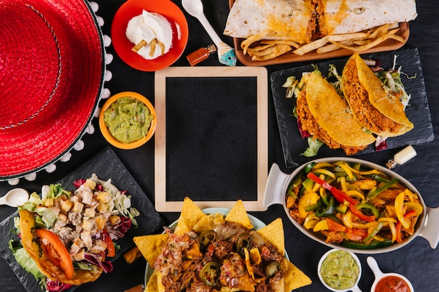 Sombrero und mexikanisches Essen nahe Tafel