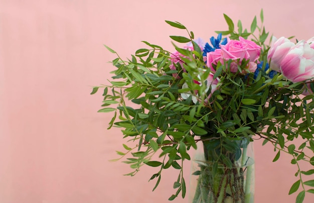 Sommerblühende zarte rosen auf festlichem hintergrund, pastell und weichem blumenstrauß. panoramablick: rosenstrauß, frühlingsfarbe. horizontale grenze: knospen, grüne blätter auf rosa hintergrund.