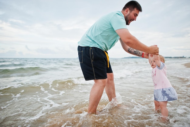 Sommerferien Eltern und Menschen Outdoor-Aktivität mit Kindern Fröhliche Familienferien Vater mit kleiner Tochter am Meeressandstrand