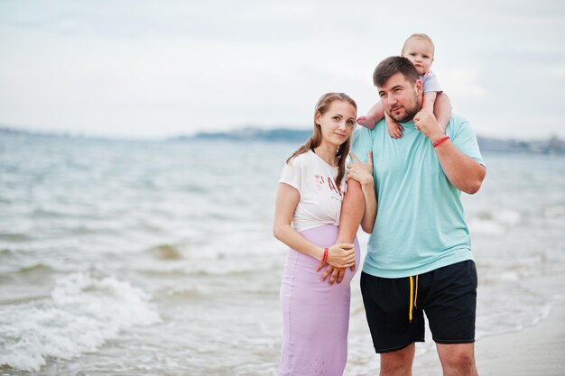 Sommerferien Eltern und Menschen Outdoor-Aktivitäten mit Kindern Fröhliche Familienferien Vater schwangere Mutter Baby Tochter am Meeressandstrand