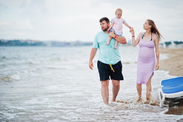 Sommerferien Eltern und Menschen Outdoor-Aktivitäten mit Kindern Fröhliche Familienferien Vater schwangere Mutter Baby Tochter am Meeressandstrand