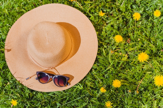 Sommerhut auf dem Gras mit Sonnenbrille