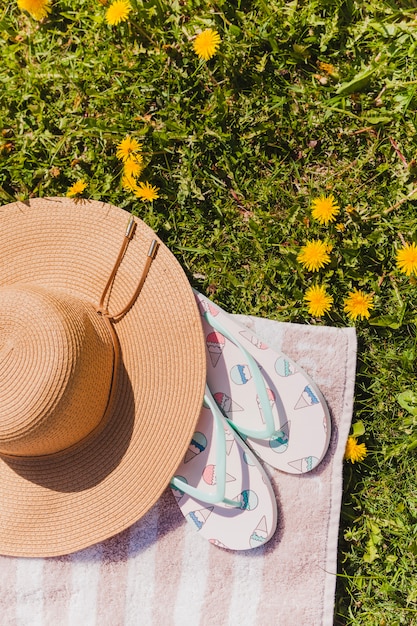 Sommerhut mit Flip Flops auf dem Feld