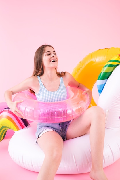 Sommermodekonzept mit junger Frau auf aufblasbarem Einhorn
