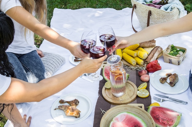 Sommerpicknick mit Freunden in der Natur mit Essen und Getränken.