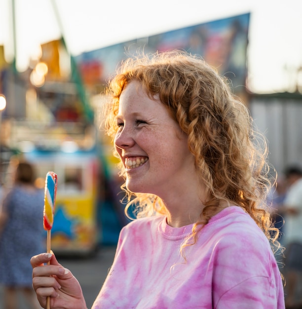 Kostenloses Foto sommersprossensmileyfrau, die einen lutscher genießt