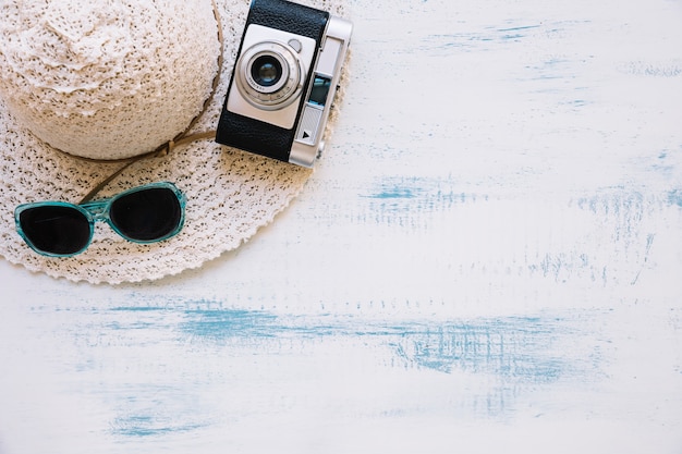 Kostenloses Foto sommerzusammensetzung mit sonnenbrille und kamera auf hut