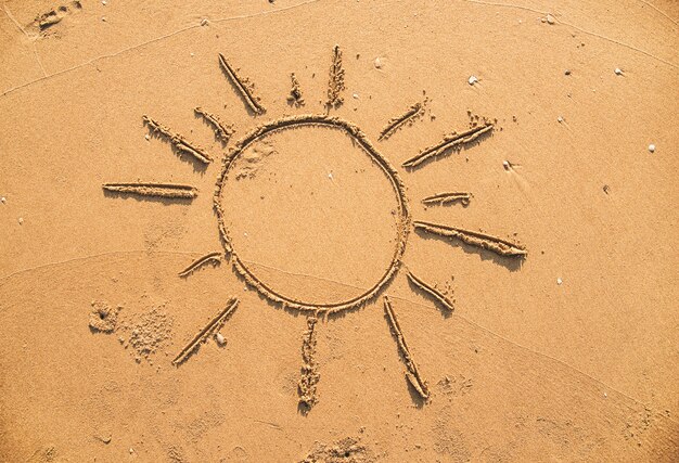 Sonne im Sand gezeichnet