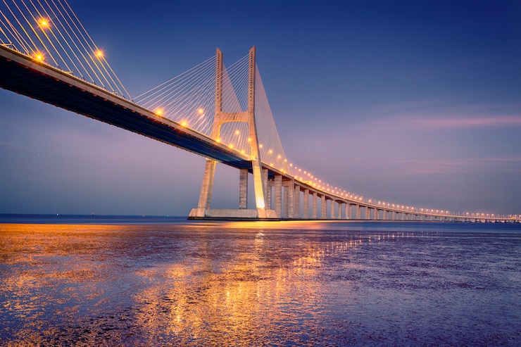 Kostenlose Foto sonnenaufgang auf vasco da gama brücke in lissabon, portugal