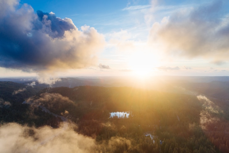 Kostenlose Foto sonnenaufgang über einer mit grün bedeckten felsformation