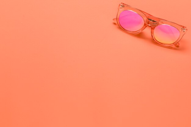 Sonnenbrille auf rosa Oberfläche