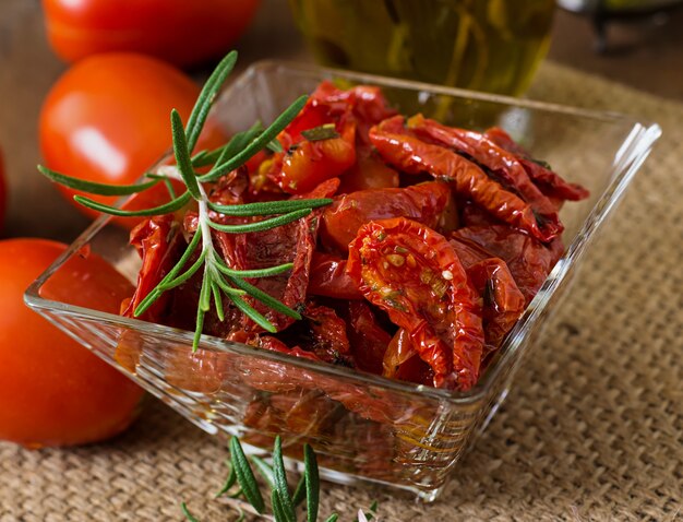 Sonnengetrocknete Tomaten mit Kräutern und Knoblauch in einer Holzschale