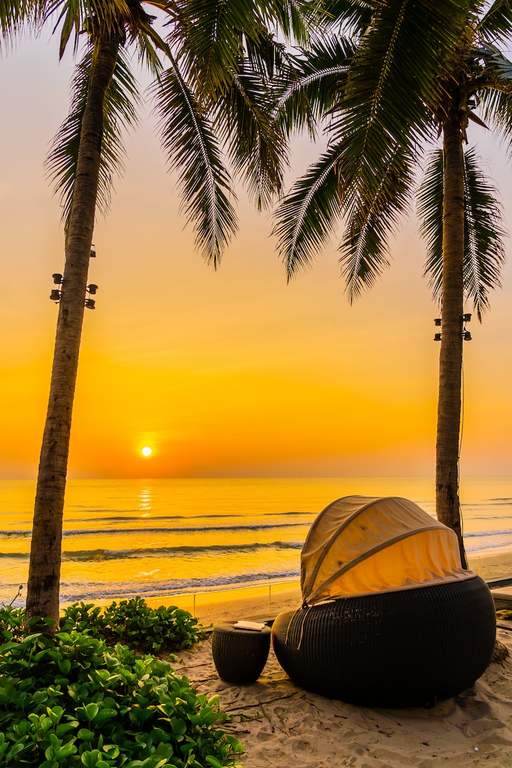 Kostenlose Foto sonnenschirm und stuhl am schönen strand und meer zur sonnenaufgangzeit für reisen und urlaub