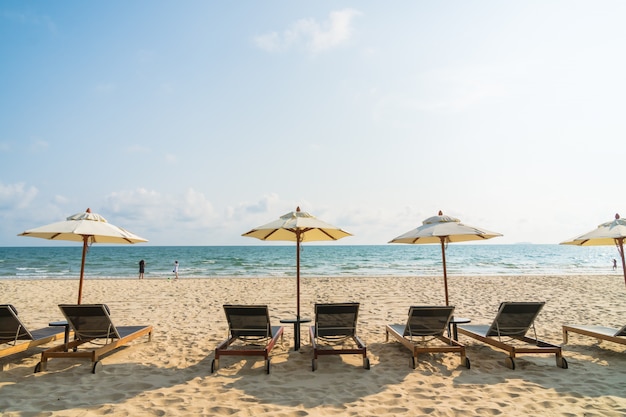 Sonnenschirm und Stuhl am Strand und am Meer