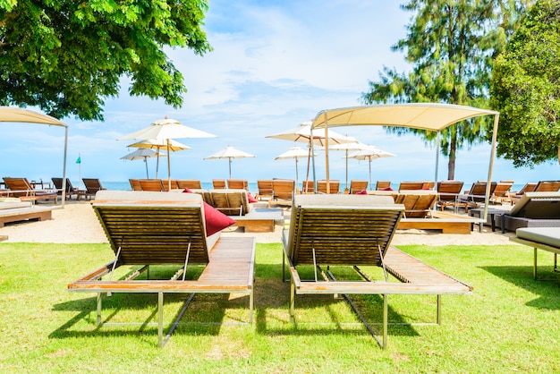 Sonnenschirm und Stuhl am wunderschönen tropischen Strand
