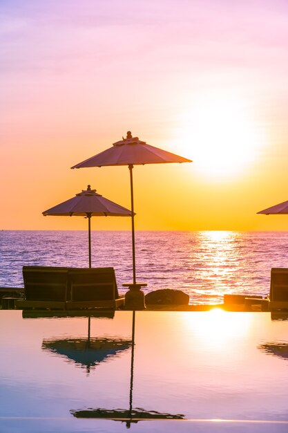 Sonnenschirm und Stuhl rund um das Schwimmbad im Ferienhotel für Urlaubsreisen und Urlaub