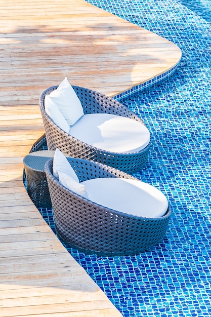Sonnenschirm und Stuhl um Außenpool im Hotelresort mit Meerblick für Reiseurlaub
