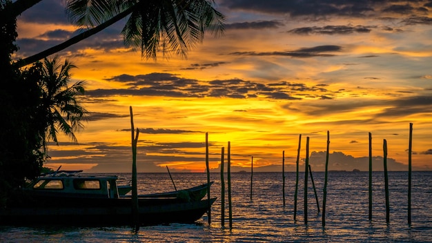Sonnenuntergang auf kri island. einige boote im vordergrund. raja ampat, indonesien, west papua.