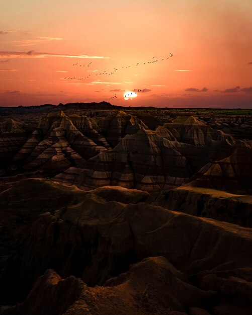 Sonnenuntergang über Ödland. Gelände mit gestreiften Felsformationen