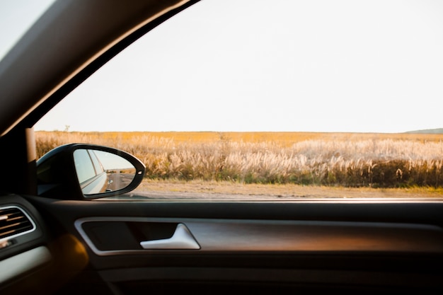 Sonnige Aussicht auf ein Feld vom eleganten Auto