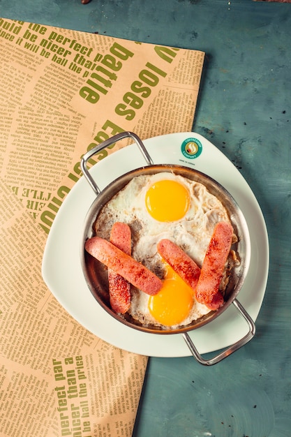 sonnige Eier zum Frühstück mit halb geschnittenen und gebratenen Würstchen