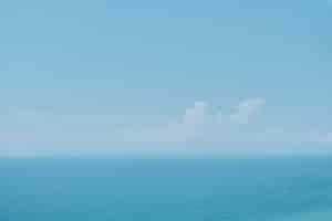 Kostenloses Foto sonniger himmel mit wolken und ruhigem meer auf mittagshintergrund weicher verschwommener fokus heißer sommerurlaub in pastellfarben und sonneneinstrahlung abstraktes unschärfeplakat oder werbebanner