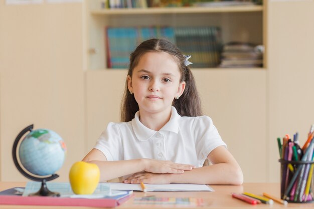 Sorgfältiger Schüler, der am Schreibtisch sitzt