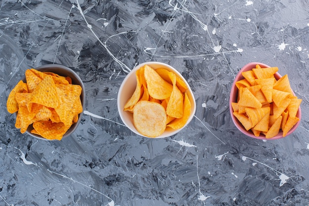 Sortiment Kartoffelchips in Schalen, auf der Marmoroberfläche