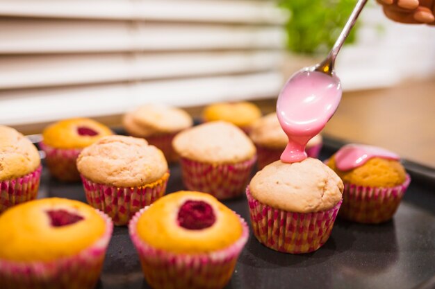 Soße, die auf kleine Kuchen fließt