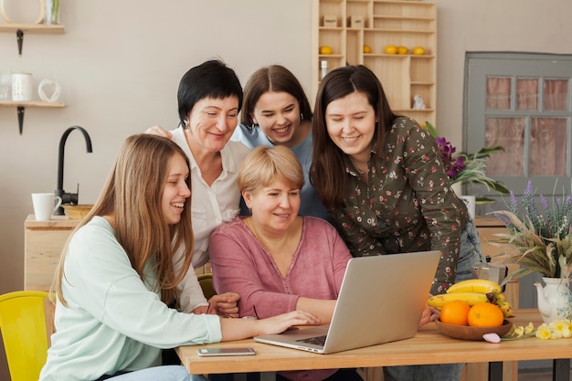 Soziale weibliche Versammlung unter Verwendung eines Laptops