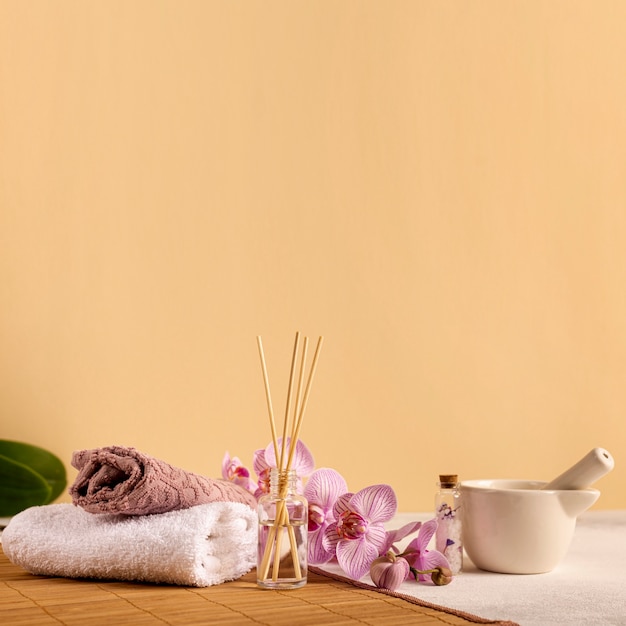 Kostenloses Foto spa-arrangement mit handtüchern und blumen