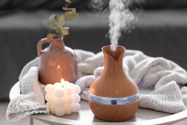 Kostenloses Foto spa-komposition mit aromaöl-diffusorlampe und kerze auf verschwommenem hintergrund