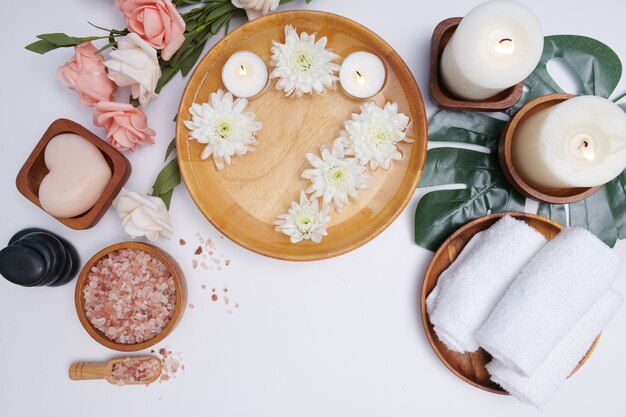 Spa-Konzept. Schönheits- und Modekonzept mit Spa-Set. parfümierte Blumen Wasser. Entspannung und Zen, Spa-Einstellung flach mit Schüssel, Badesalz und Blumen, Handtuch und natürlicher Seife. Draufsicht.