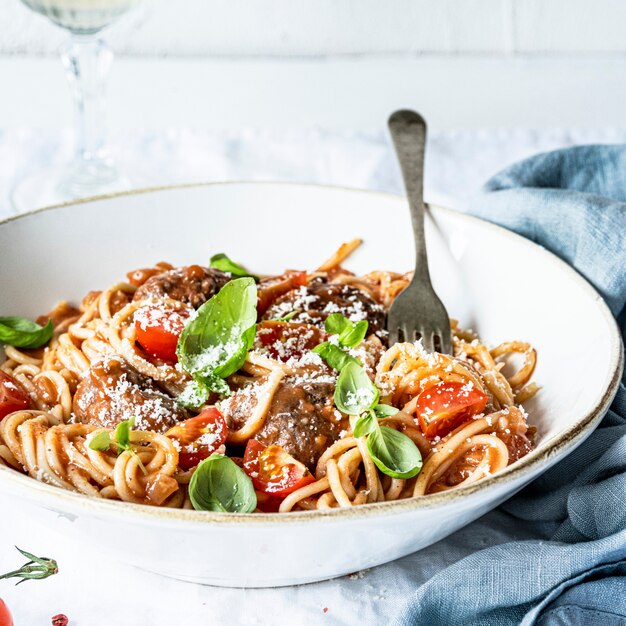 Spaghetti-Frikadelle mit Marinara-Tomatensauce, garniert mit Parmesan und Basilikum