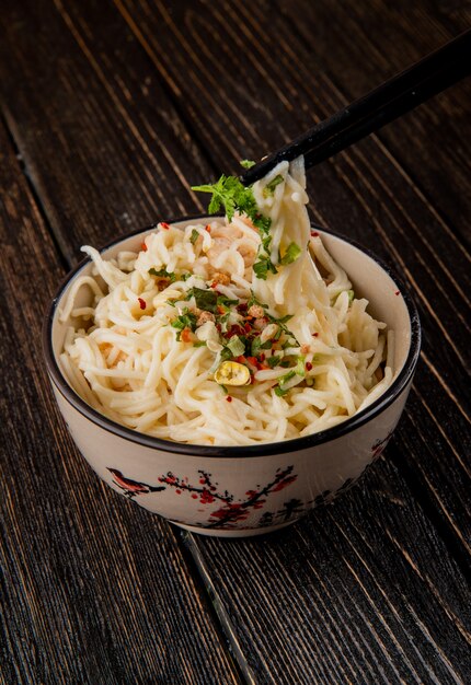 Spaghetti im japanischen Stil, aufgenommen von Stöcken aus der Seitenansicht der Schalengrüngewürze